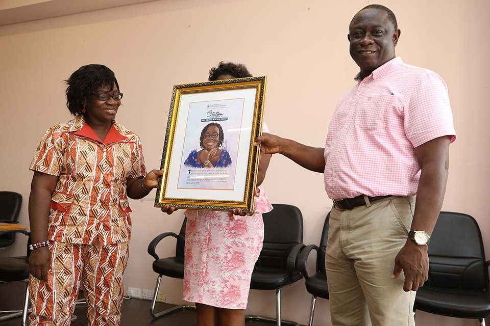 Deputy Registrar, IDeL, Mr. William Agyei-Bieni assisting Mrs. Juliana Ohene Boateng to receive her citation
