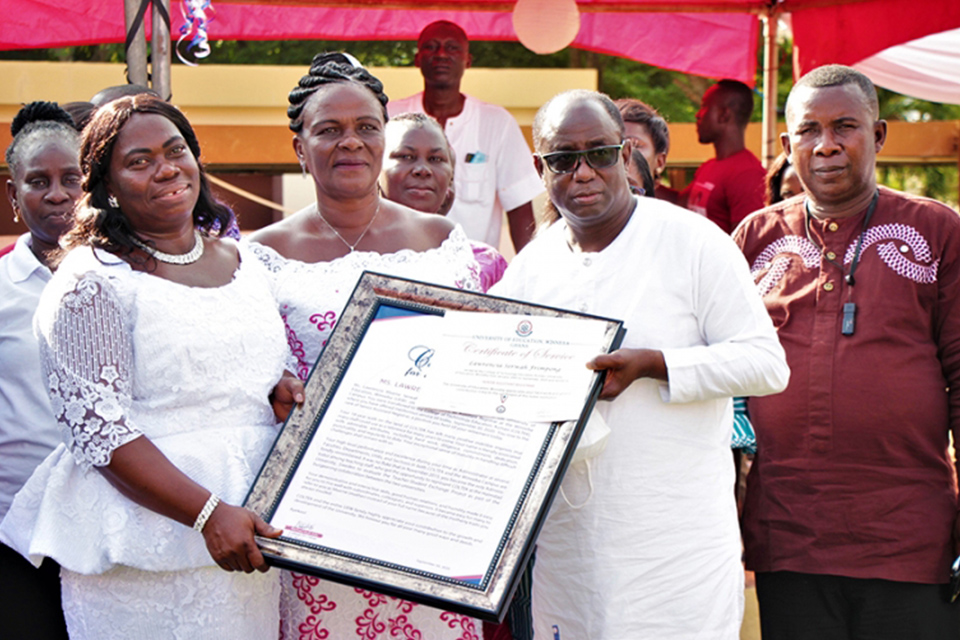 Ms. Lawrencia Serwah Frimpong (in a white lace dress) receiving her citation from Rev. Prof. Joseph Mbawuni, Dean of the Faculty of Technical Education (FTE)