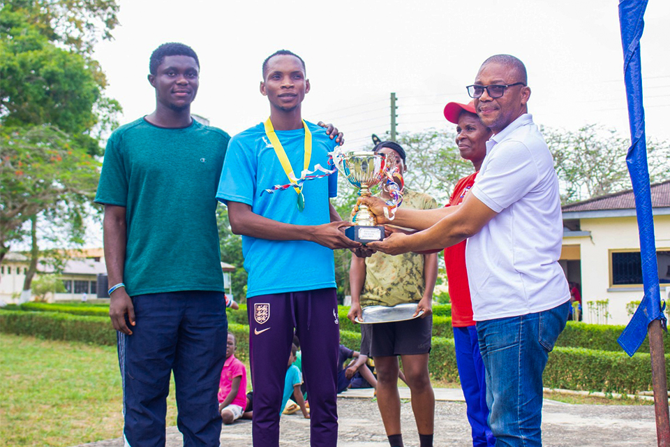 Mr. Andy Agordah (right) presenting the ultimate trophy to the captain of University Hall