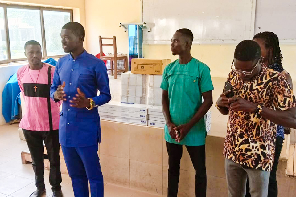 Mr. Emmanuel Mensah, dressed in blue attire, explaining the inspiration behind the gesture 