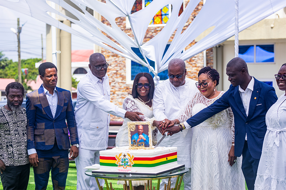 The UEW delegation joins the President in cutting his birthday cake