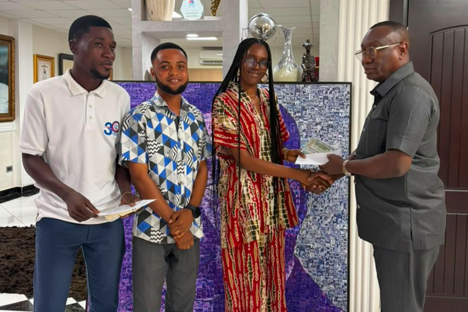 Dr. Ernest Ofori Sarpong (right) presenting a token of support to the three student artists
